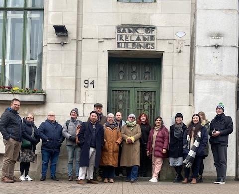 15 people standing outside the old Bank of Ireland buildings on Royal Avenue Belfast