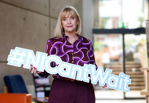 NICVA CEO Celine McStravick holding the #NICan'tWait campaign sign