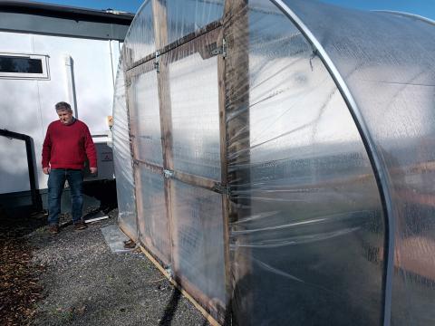 Alan McDowell by one of the greenhouses