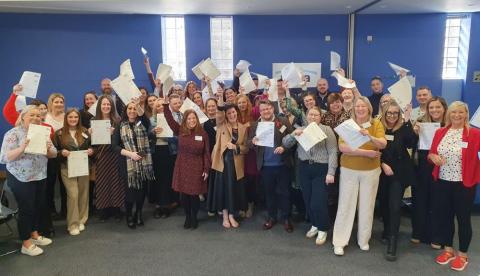 Photo of NICVA's Roisin Kelly pictured with all our graduates and their certificates