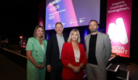 From Left: Broadcaster Sarah Travers, CEO of Pro Bono Economics Matt Whittaker, CEO of NICVA, Celine McStravick and Chair of NICVA Stephen Dallas stand in front of the stage at the NICVA Summit 2026
